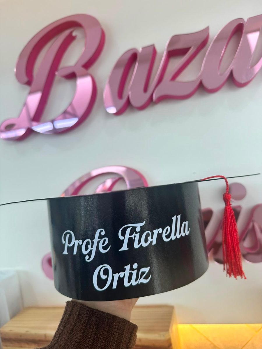 Birrete de graduación con el nombre de una profesora y una frase